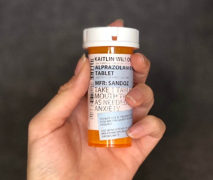 hand holding a bottle of xanax